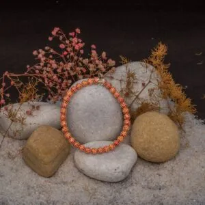 JBRC1018 — THE EMBER BEADS: Orange and white stone-set spheres form a vivid bracelet with a warm, continuous glow.