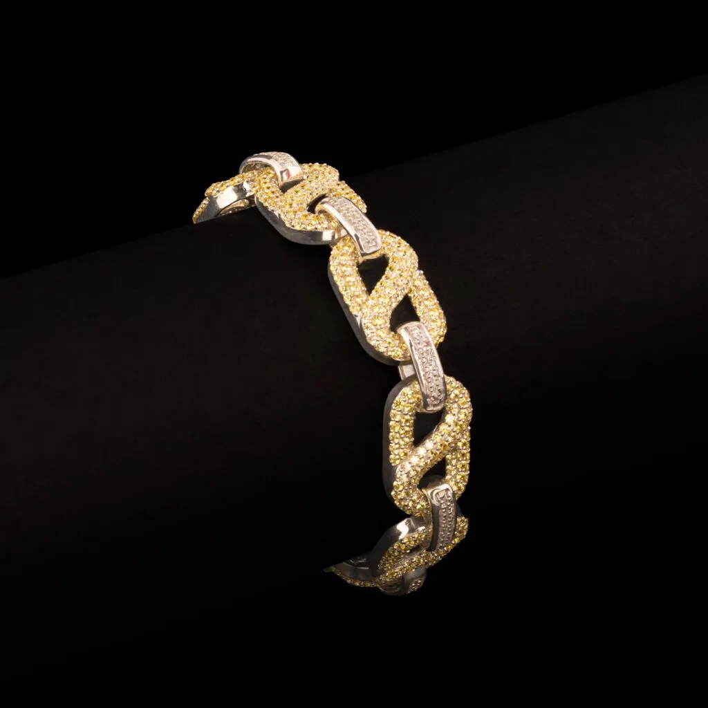 JBRC1021 — THE GOLDEN UNDERTOW: Sweeping open links combine yellow stone-set curves with bright metal arcs in a flowing, two-tone composition.